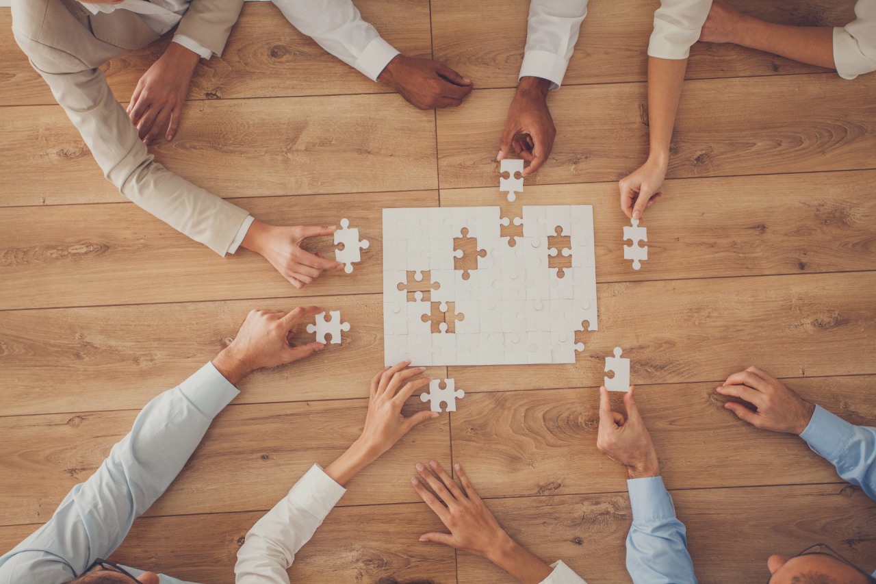 Kodeks etyki. Ludzie układający puzzle dążą do osiągniecia wspólnego celu.